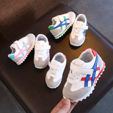Children's sneakers with colorful accents on a dark surface